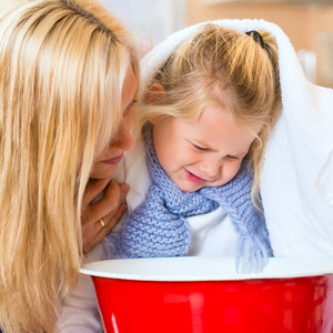 Mother reassures daughter to inhale over a bowl