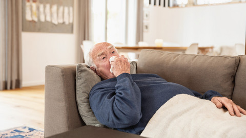 Elderly sick man lying on the couch