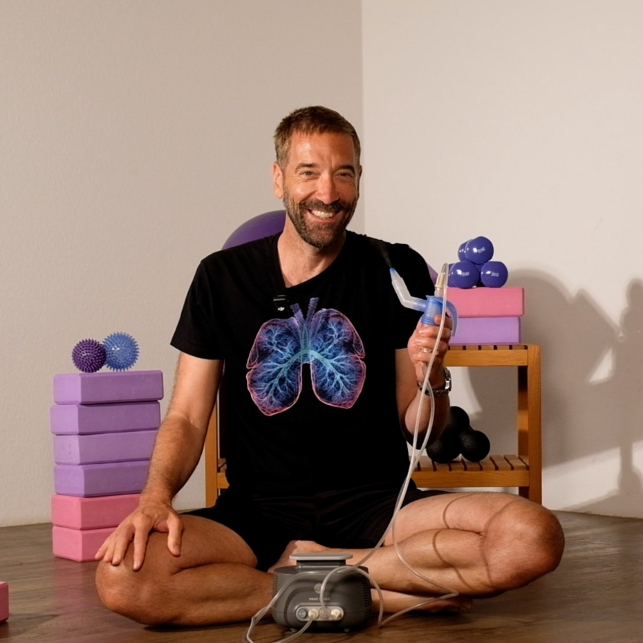 Nik Linder sitzt im Schneidersitz auf dem Boden, vor ihm steht der PARI SINUS2, in der Hand hält er den SINUS Vernebler