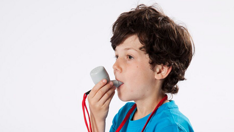 Junge sitzt mit Buch am Boden und atmet in das PARI O-PEP