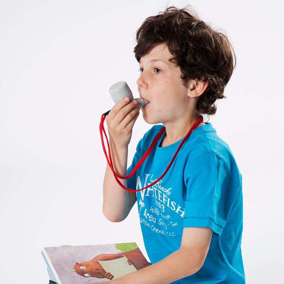 Junge sitzt mit Buch am Boden und atmet in das PARI O-PEP