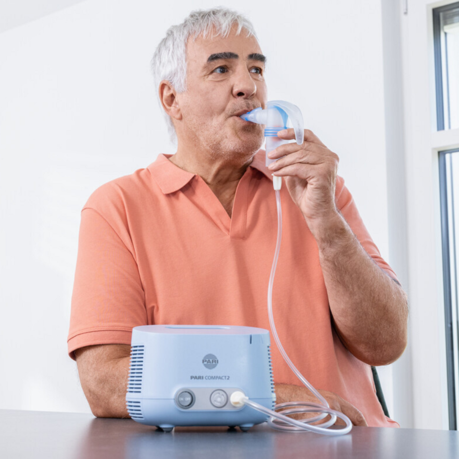 Älterer Mann inhaliert mit dem PARI COMPACT2 Inhalationsgerät mit Vernebler 