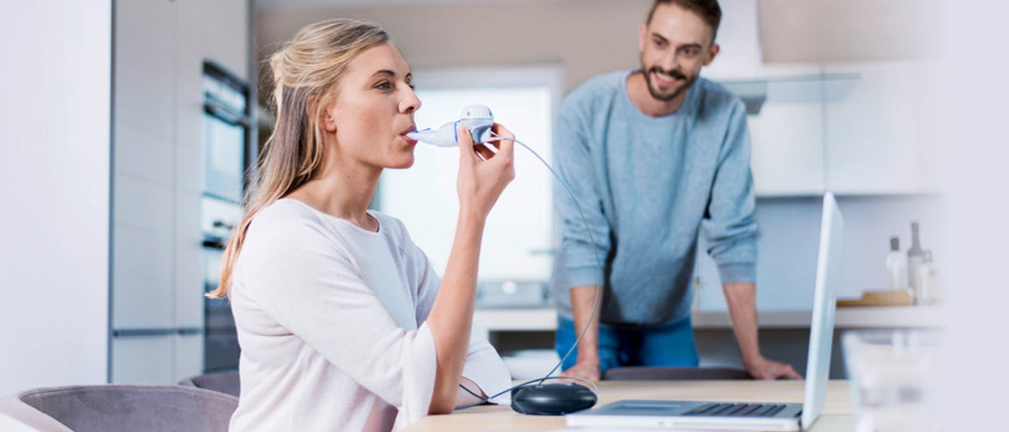 Woman inhales for treatment of cystic fibrosis