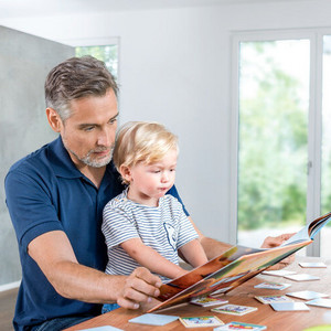 What can be done if a child has mucus in their throat: Words starting with an M Father sitting with son at the table with a book open in front of him