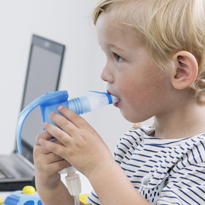 Little boy inhales with nebuliser