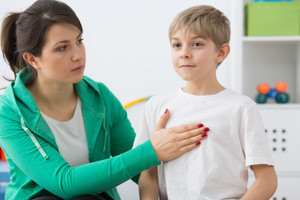 Woman holds hand on child’s chest during breathing exercise