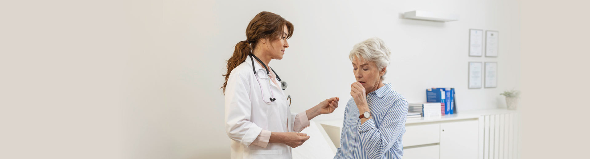 Doctor examining elderly woman with breathing difficulties in modern office, medical records and equipment in the background.