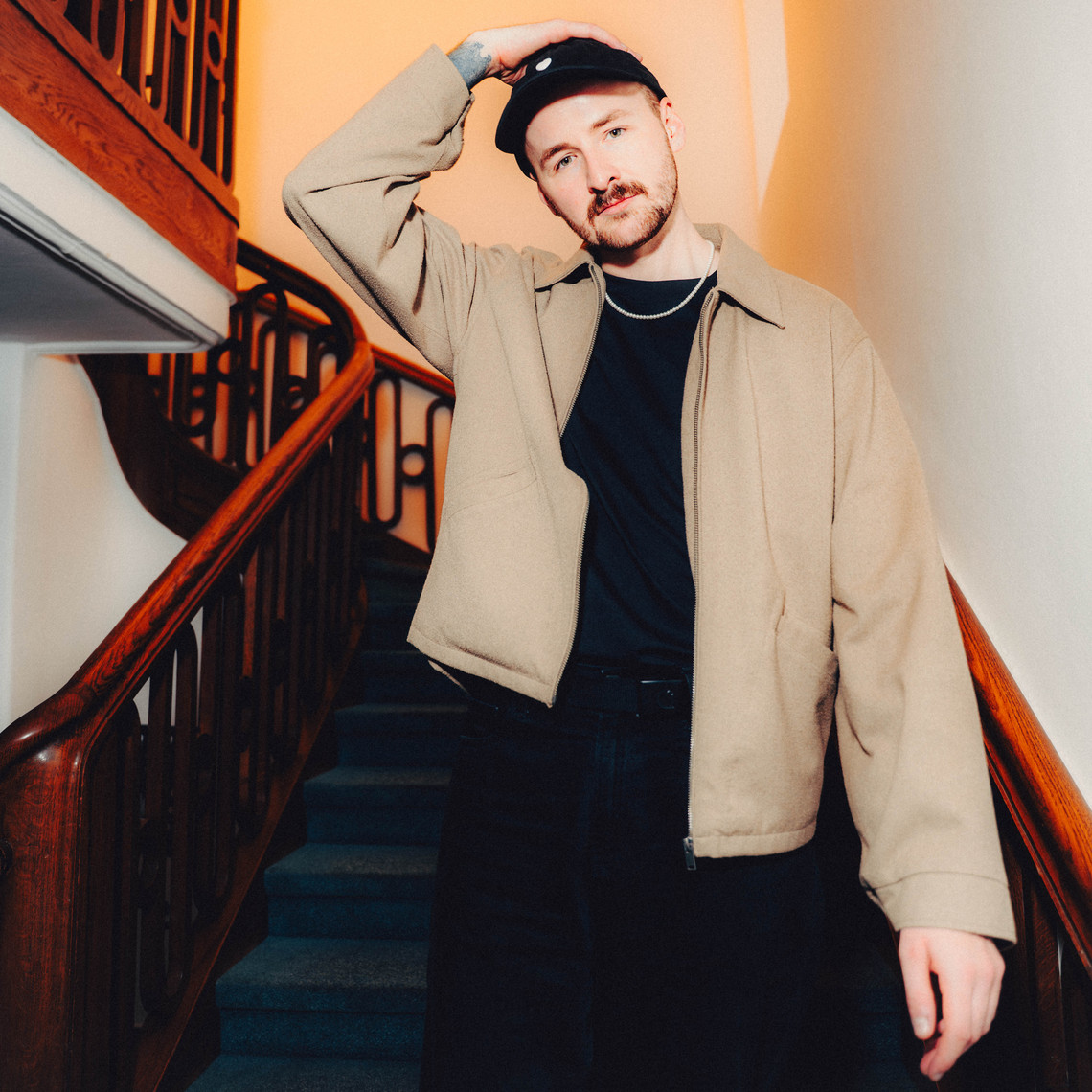 Professionelle Gesangskarriere trotz PCD: Interview mit Sänger Dominik Gassner Sänger Dominik Gassner in einem Treppenhaus