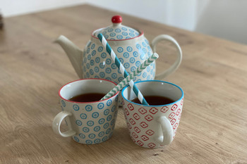 Jug and two cups with straws on the table