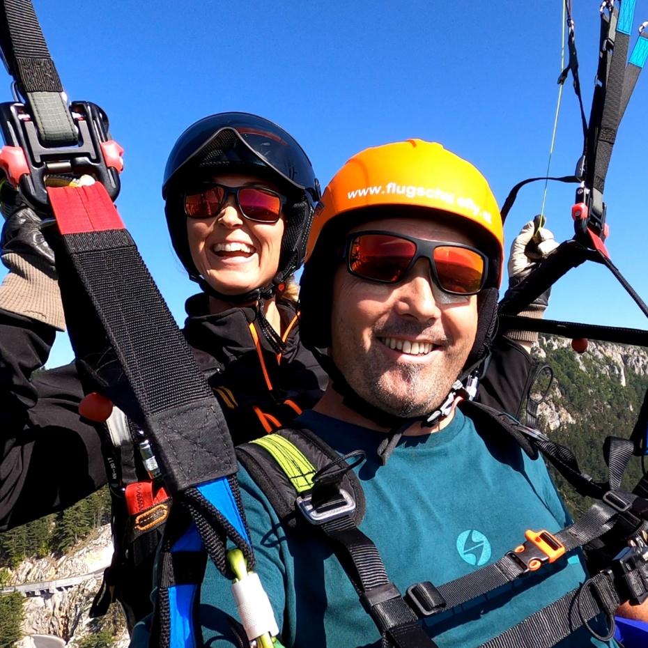 Halbnahaufnahme während eines Tandemflugs von Pilotin und Fluggast im Schirm hängend