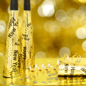 Nahaufnahme von goldenen Faschingströten, auf denen "Happy New Year" steht