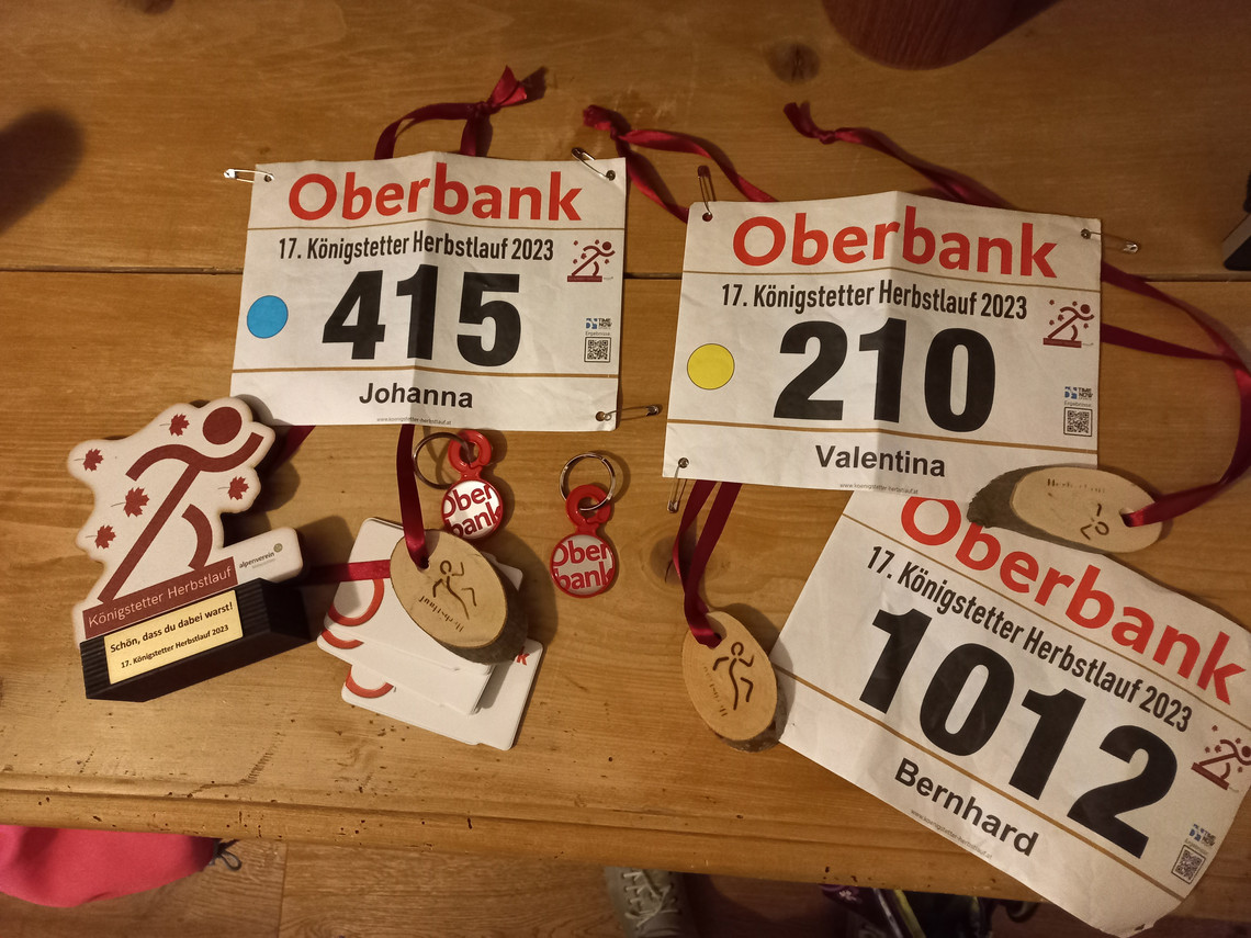 Aufnahme von oben von Startnummern und Auszeichnungen eines Laufwettbewerbs auf einem Tisch liegend