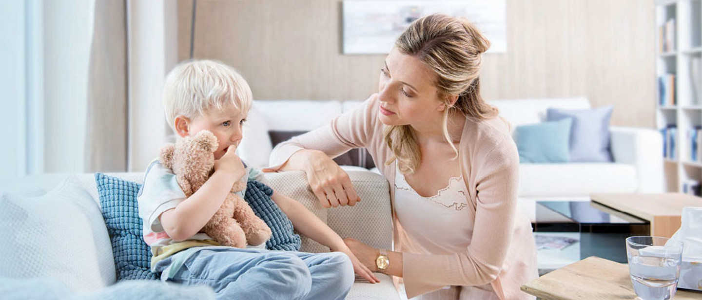 Person demonstrating inhaler use with healthcare professional at a table