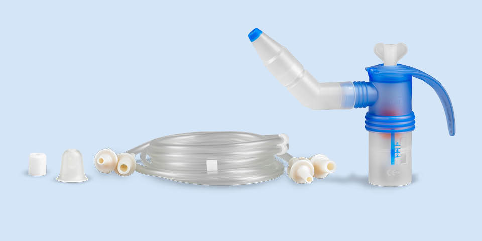Produktabbildung: Vor einem blau-grauen Hintergrund steht rechts ein PARI LC SPRINT SINUS Vernebler mit Winkel und Vibration-Anschluss. Links daneben liegt der Anschlussschlauch, daneben ein Nasenstöpsel und ein Filtereinsatz für den Kompressor.