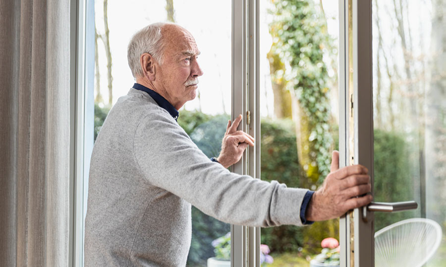 Ein Mann öffnet das Fenster zur Vorbeugung einer Erkältung 