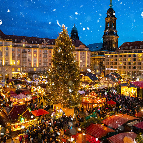 Bild eines von vielen Lichtern beleuchteten Weihnachtsmarktes in einer Stadt