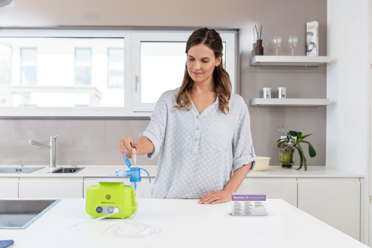 Long COVID: PARI Boy und MucoClear 3% Frau füllt in Küche Inhalationslösung in das Inhalationsgerät