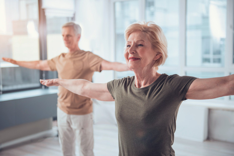 Older woman and man doing yoga