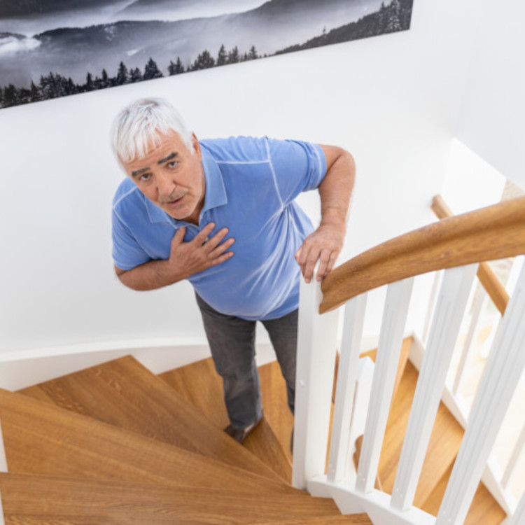 Älterer Mann steht auf Treppe mit Hand auf der Brust