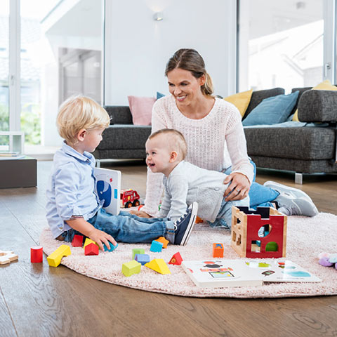 Eine Mutter spielt mit ihren beiden Kindern