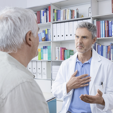 Ein Arzt spricht mit einem älteren Patienten über Inhalationstherapie