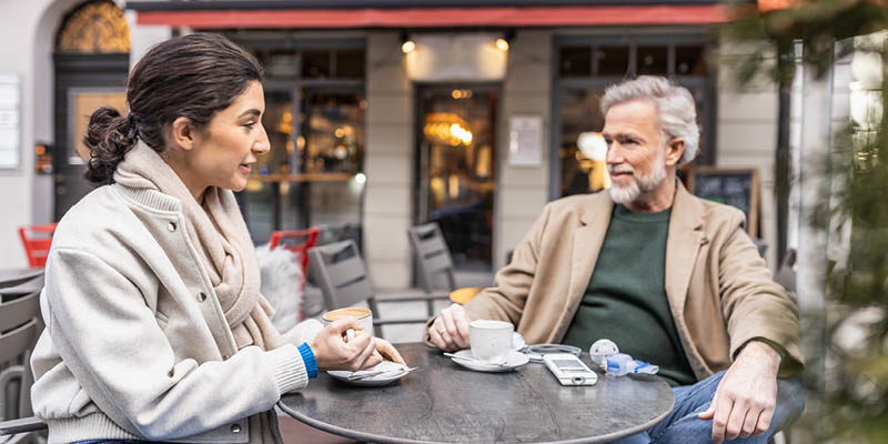 Ein Paar sitzt in einem Straßenkaffee und unterhält sich
