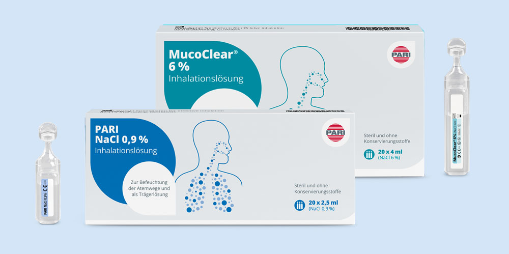 Zwei Verpackungen von PARI Inhalationslösungen vor hellem Hintergrund. Im Vordergrund die blaue Packung 'PARI NaCl 0,9% Inhalationslösung' mit 20 Ampullen für die Befeuchtung der Atemwege. Dahinter eine grüne Packung 'MucoClear 6% Inhalationslösung' zur Sekretmobilisation bei Atemwegserkrankungen. Jeweils eine Ampulle steht neben den Verpackungen.