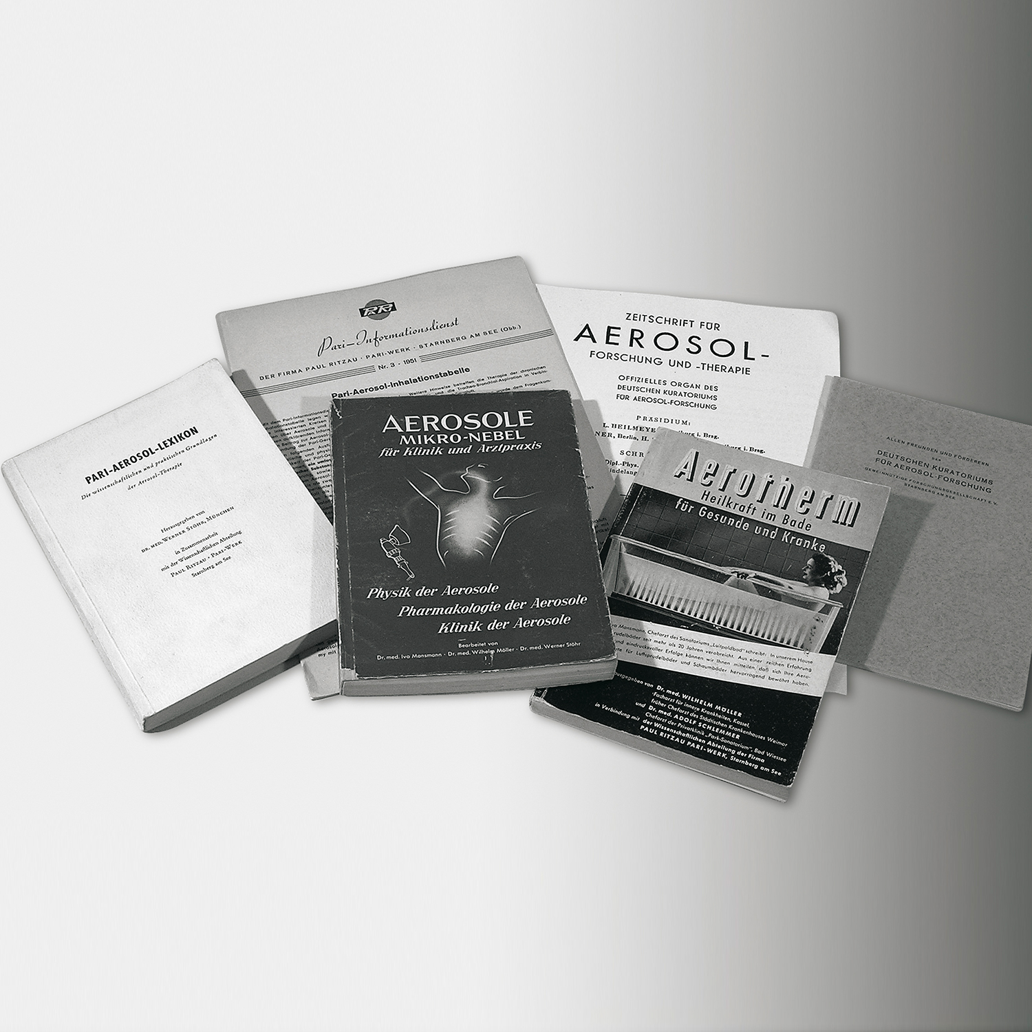 Mitbegründung des Kuratoriums für Aerosolforschung– Mehrere Fachbücher und Zeitschriften zum Thema Aerosole und Inhalation liegen auf einer Fläche.