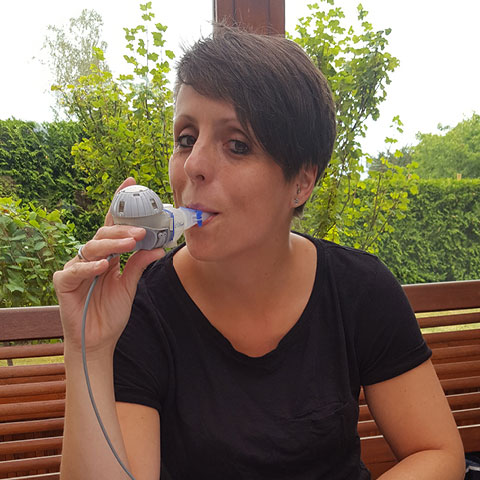 Christine Braune inhaling on her balcony.